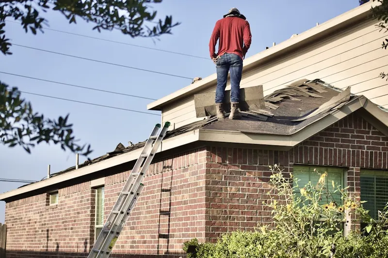Professional roofer working on a residential roof in Butts Corner